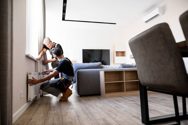 two workers fixing heating radiator for winter to earn extra money 