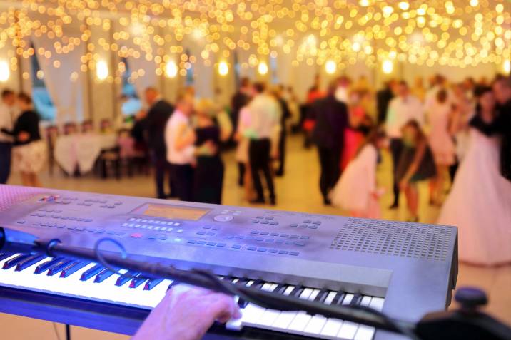 keyboard player performing at winter wedding reception in front of dancing couples