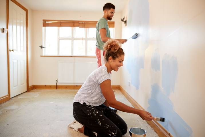 Couple painting a wall. House painting side hustle