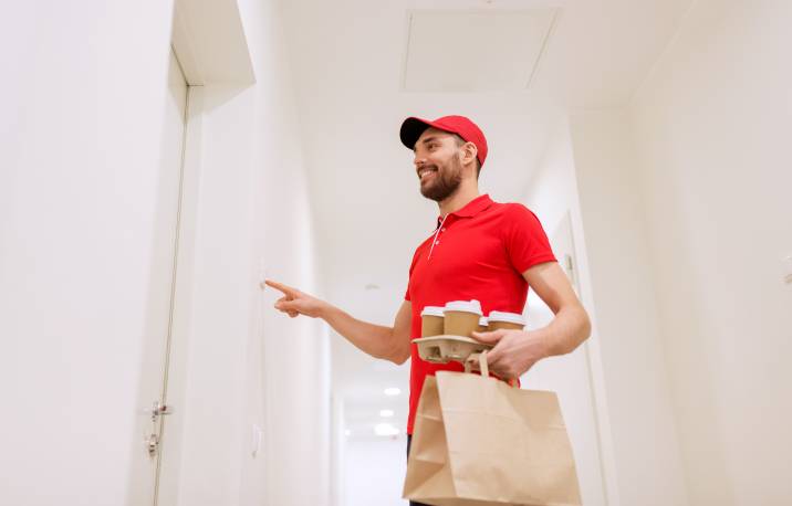Happy man ringing doorbell, delivering coffee to earn extra cash, easy job
