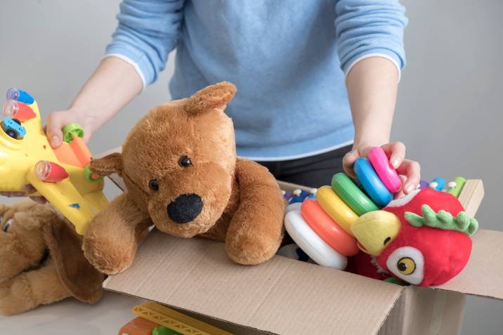 Mom holding a box of old toys to sell at a garage sale