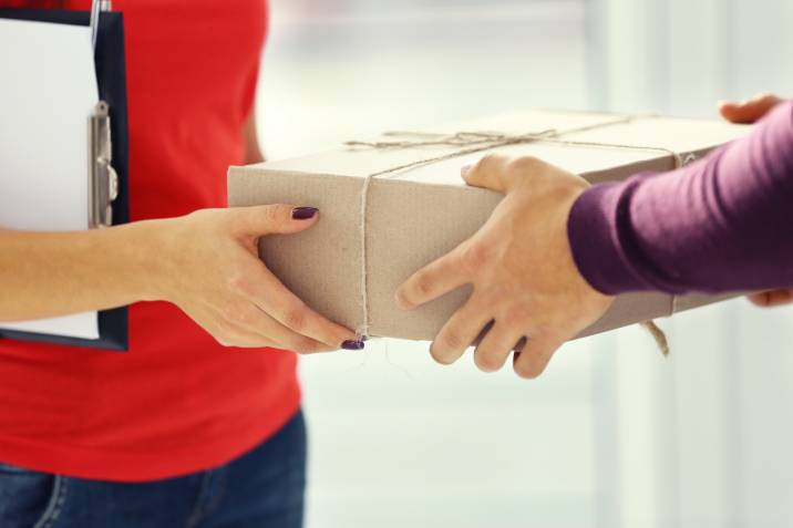 Closeup hands, handing package in a box 
