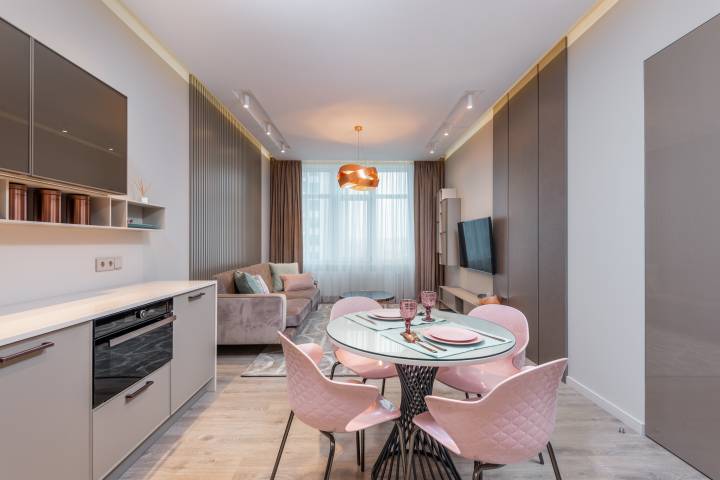Pink interior of modern kitchen and dining area in apartment