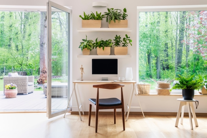 an indoor office nook with lots of plants and a view