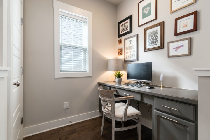 a minimalist home office with a grey desk and plenty of drawers