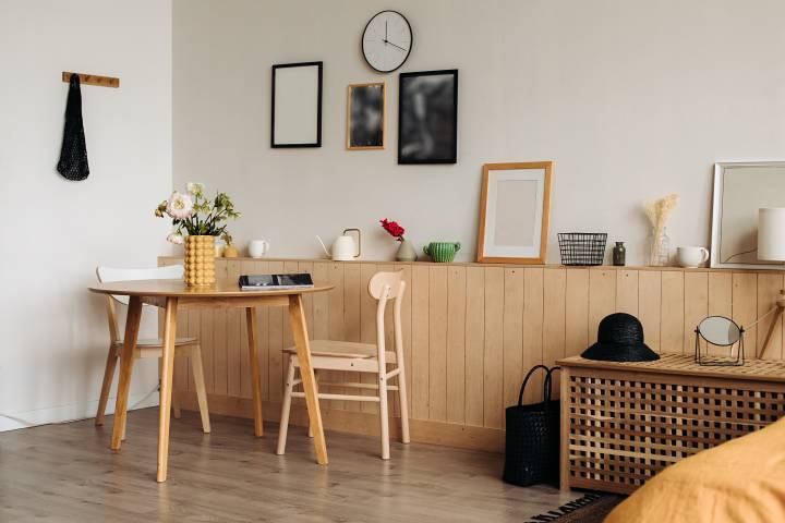 Wooden round dining table in a bright home interior.