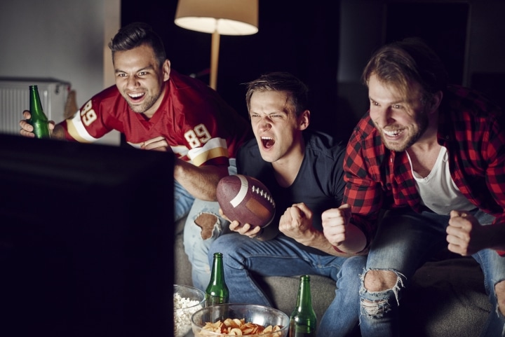 football fans watching a game in front of a television