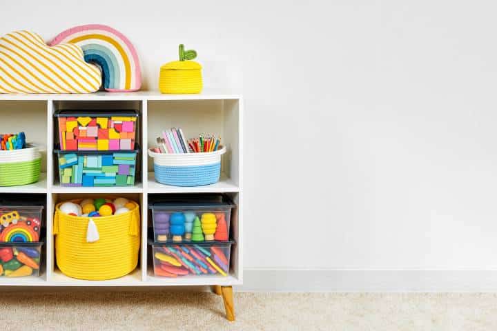 White shelving with rainbow wooden toys and colorful storage baskets and boxes