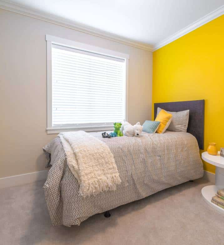 Yellow feature wall. Nicely decorated child's bedroom