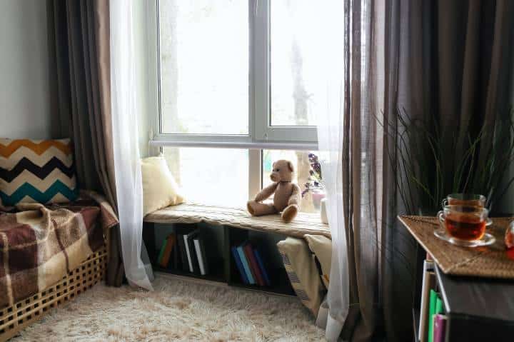 Cozy place for rest with shelf near window in room