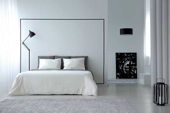 white minimalistic bedroom interior with king-size bed, lamps and painting