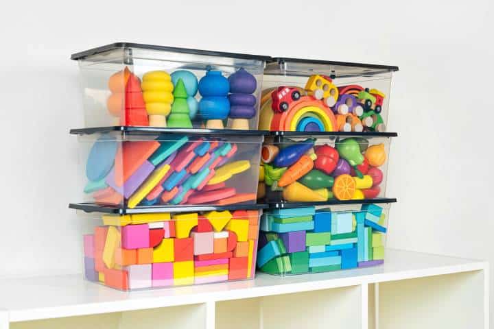 Transparent plastic containers with various children's toys on shelves