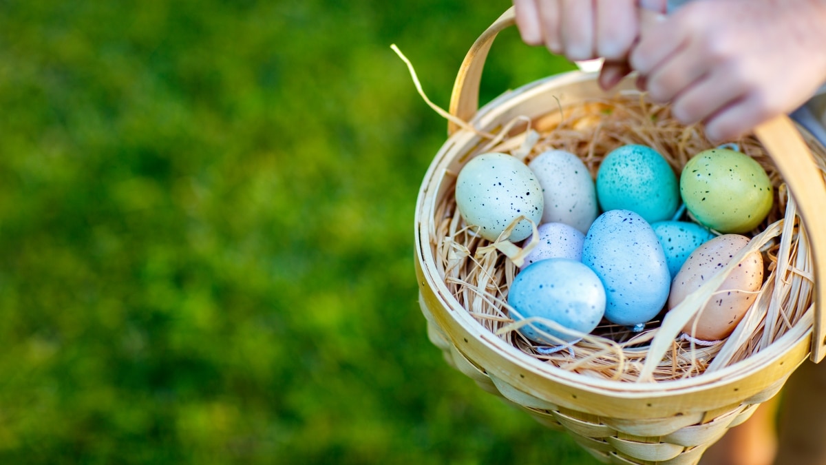 a child holding a basket full of colorful Easter eggs