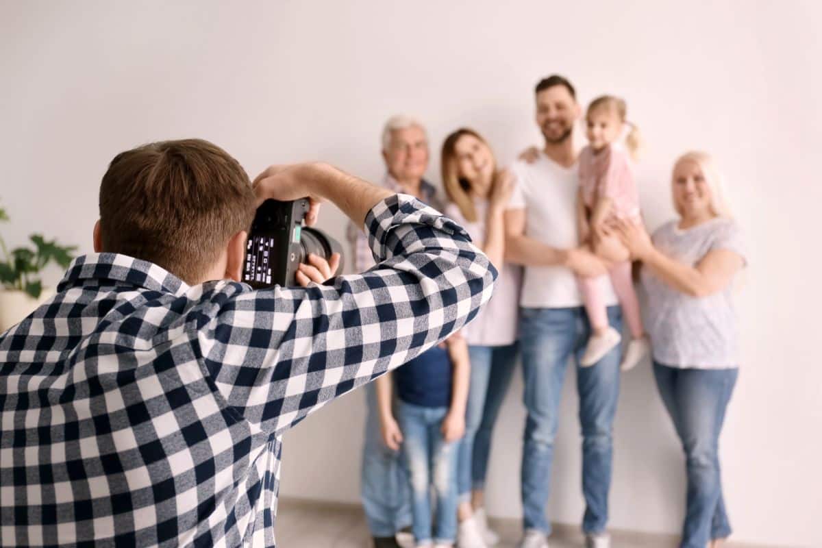 Professional photographer taking photo of family in living room, Mother’s Day photoshoot 