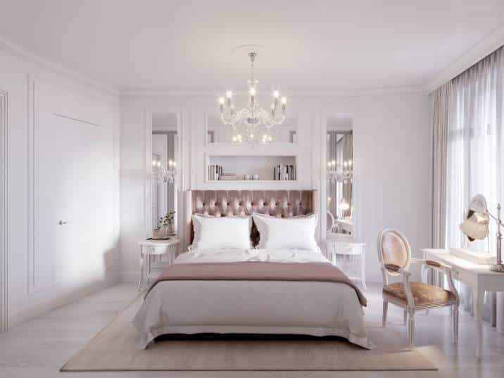 Glamorous dusty rose bedroom. Spacious and bright bedroom with large window, white walls, mirror panels, white elegant furniture. Blush pink bedding and headboard 