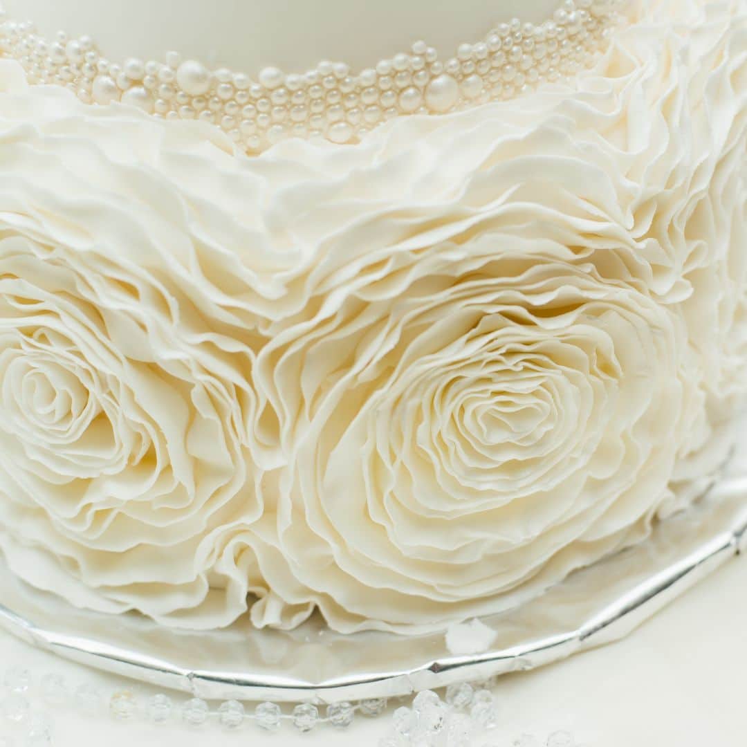 close up of a wedding cake with petal piping detail