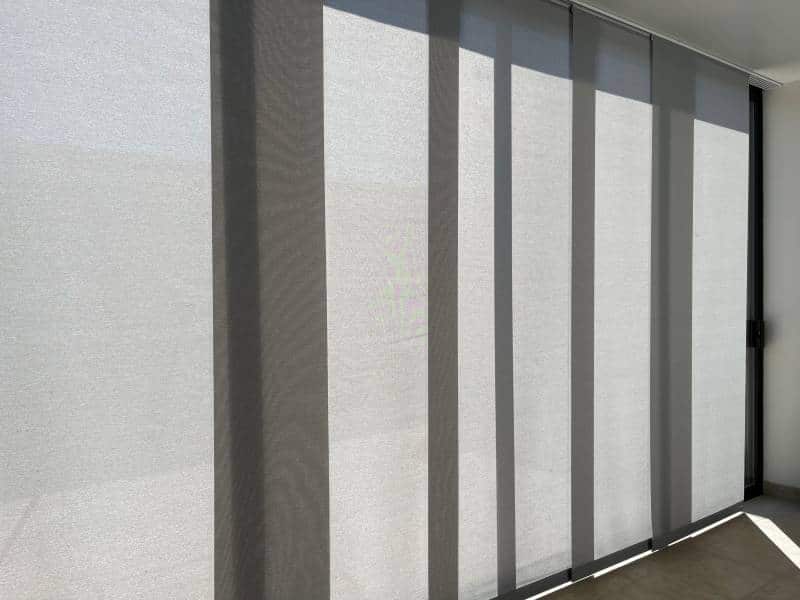 floor-to-ceiling panel blinds blocking out the sun