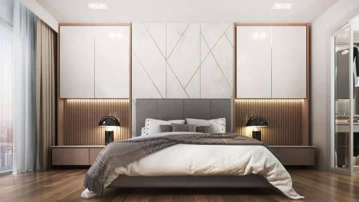 Spacious bedroom with geometric-patterned wall. Symmetrical sides with drawers and bedside lamps