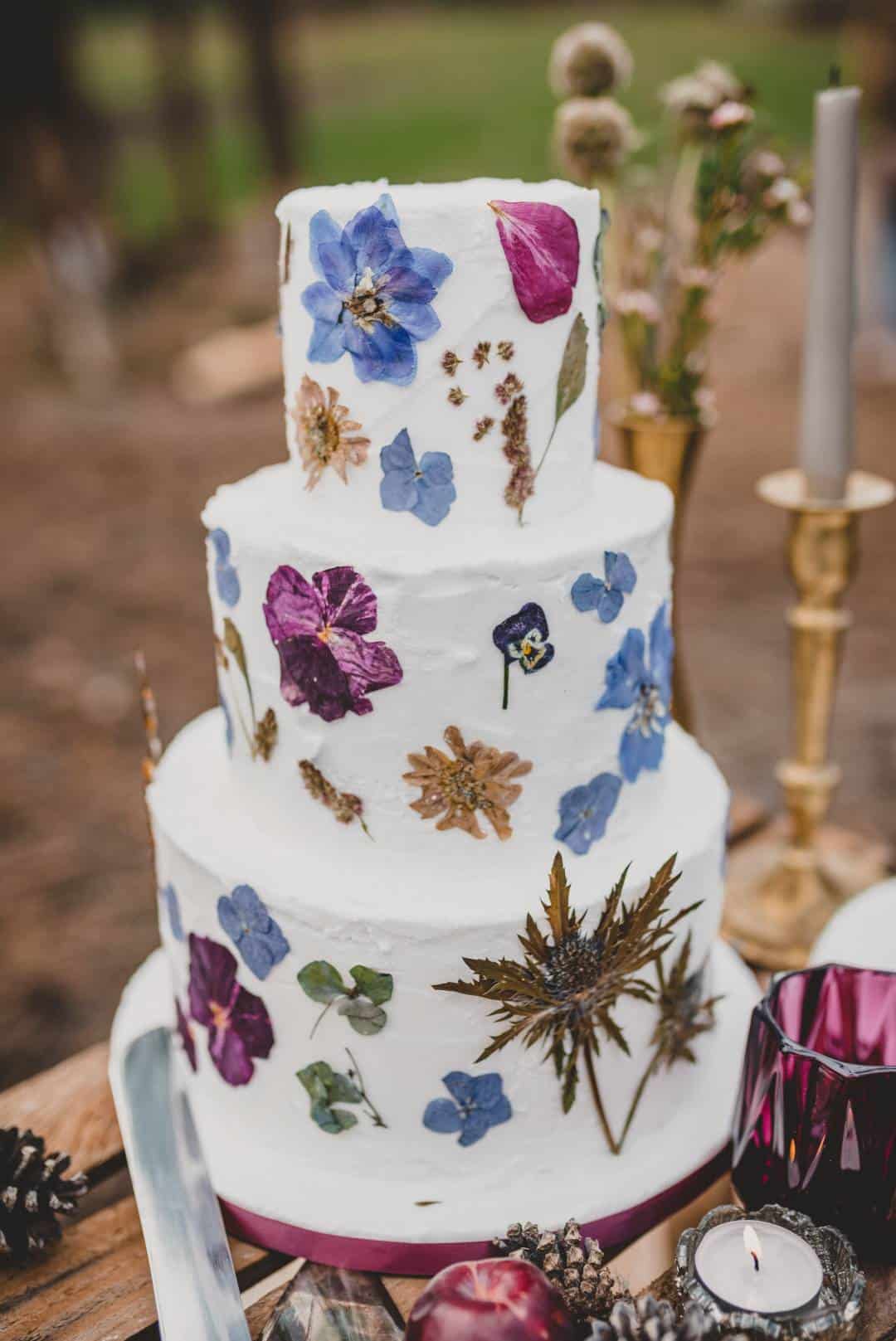 three-tiered white wedding cake with vintage floral detail