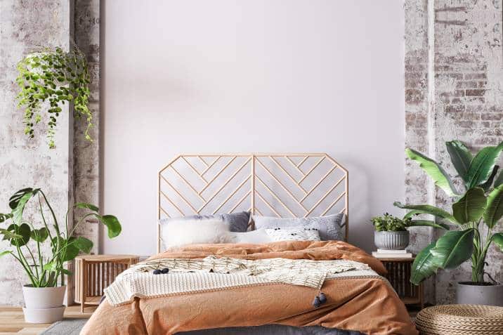 wooden bed with nearby plants in loft apartment 