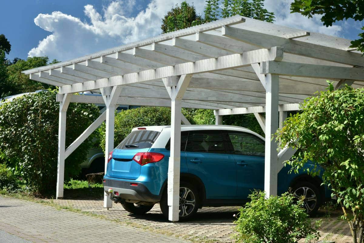 wooden carport with brick floor paving, rain gutter, and rainwater pipe