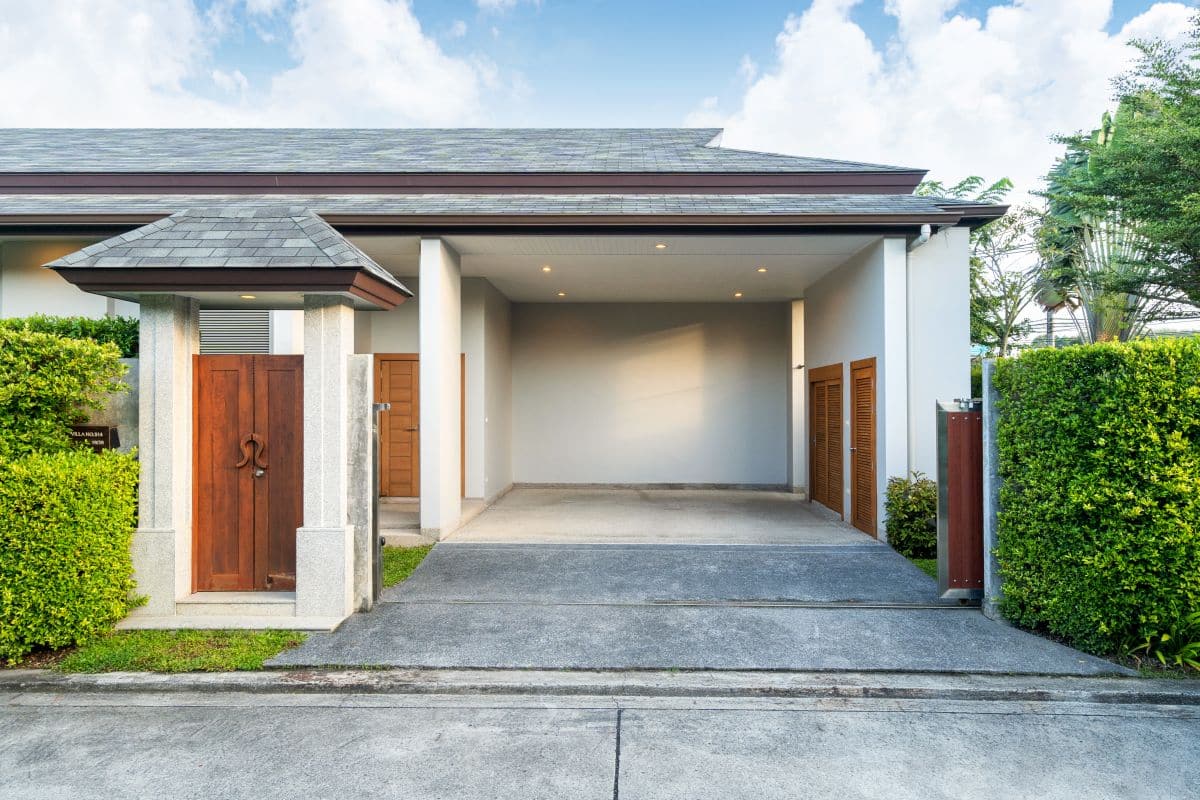 small wooden gate opened up to a carport with wood accents