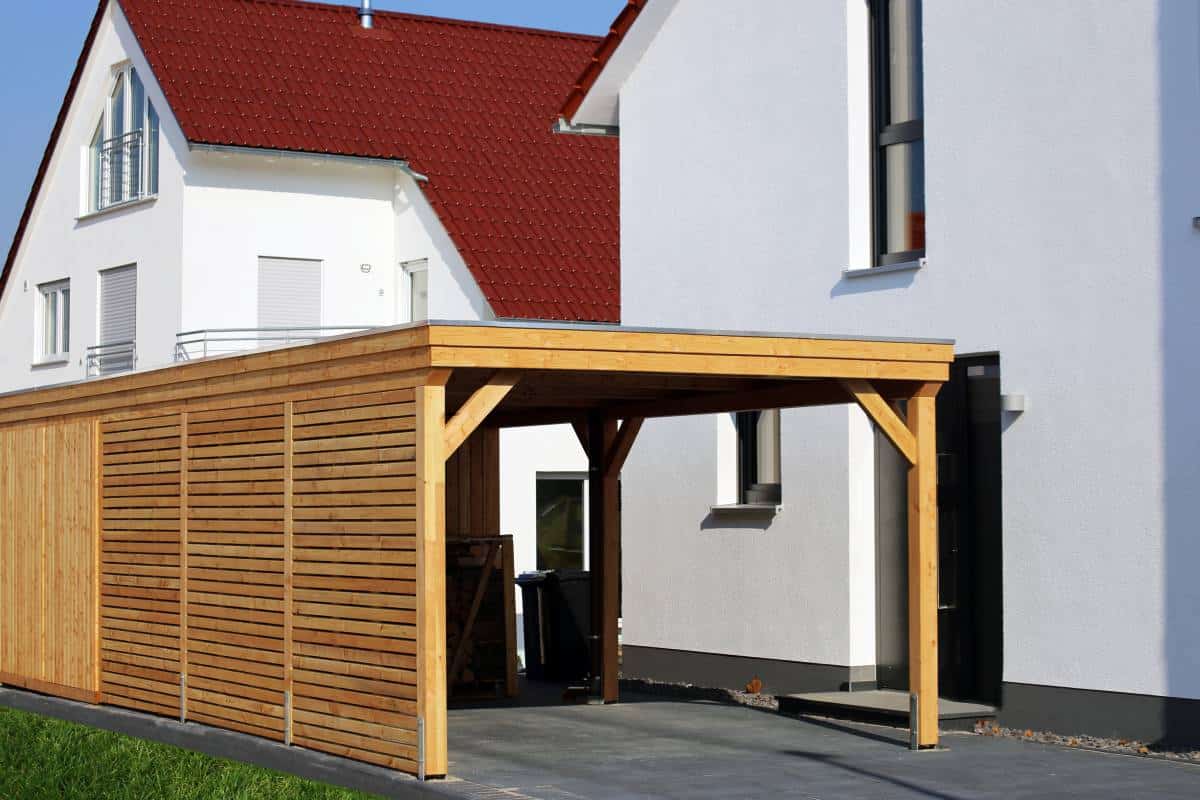 freestanding wooden carport shed near a house 