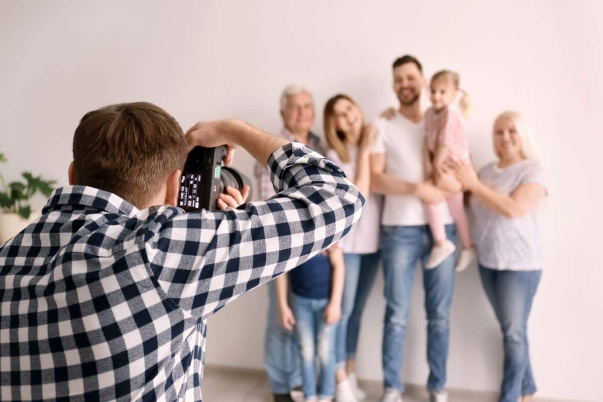 Professional photographer taking photo of family in living room, Mother’s Day photoshoot