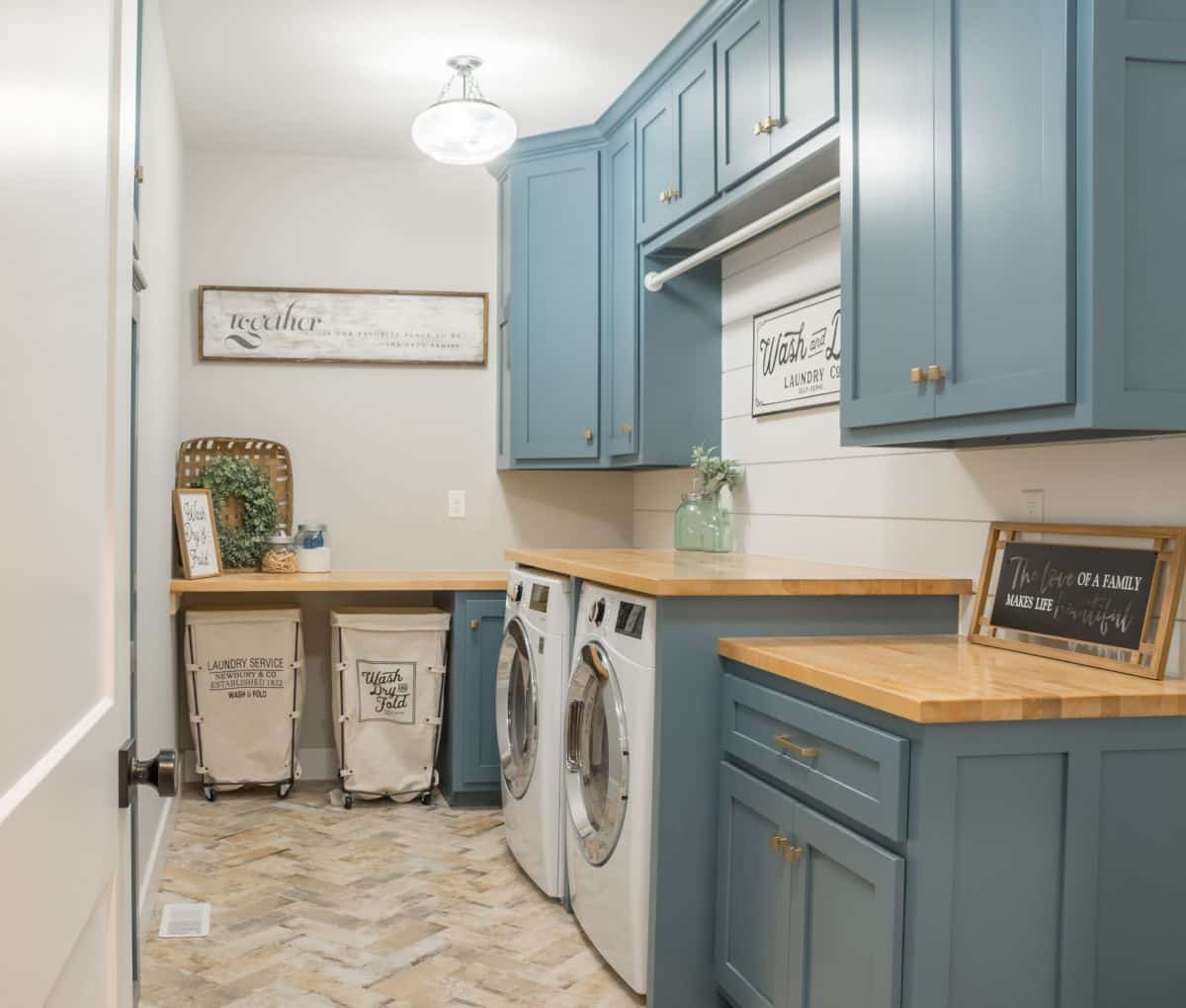 Laundry rolling carts under the counter. Farmhouse-style laundry room