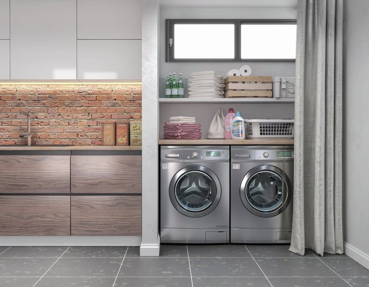 Small laundry area inside closet with curtain cover. Shelving above the appliances