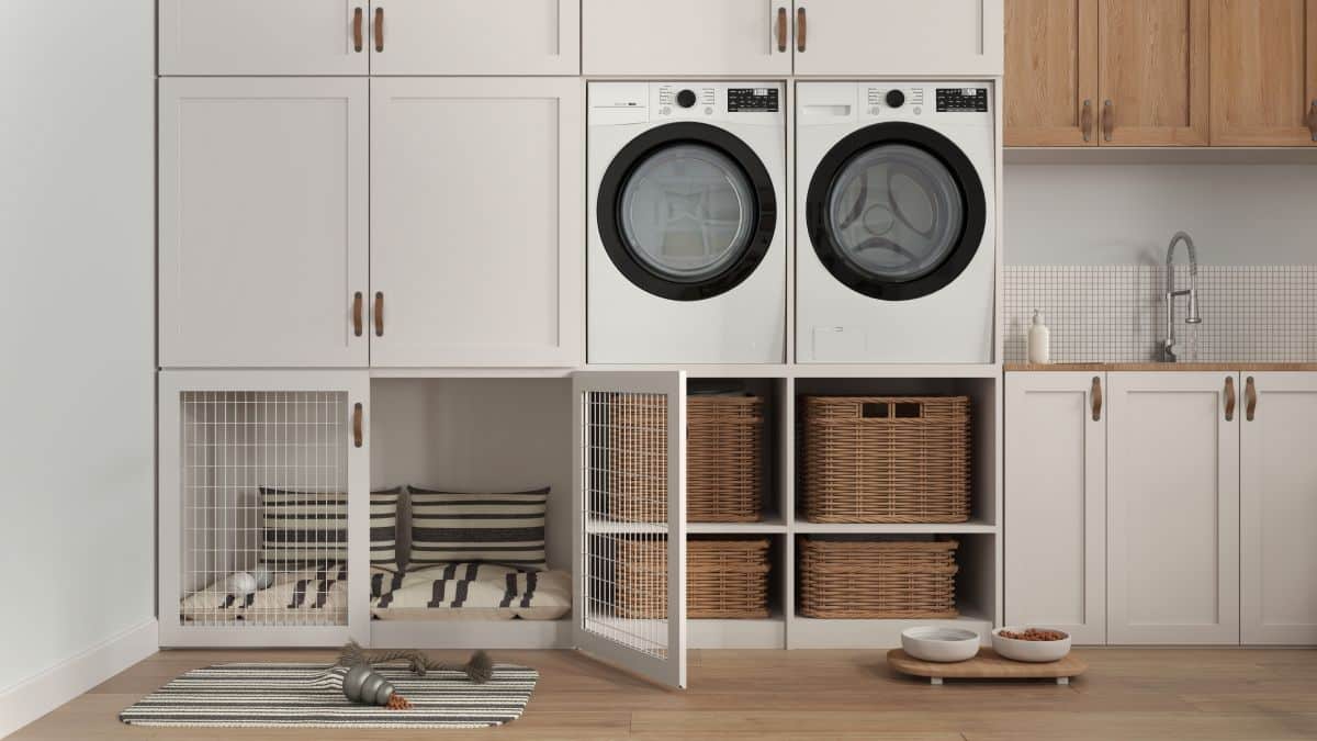 Laundry room and mudroom with dryer and washing machine. Built-in dog bed with pillows under laundry cabinet