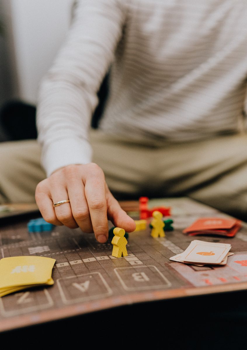 Man taking counter on game board, family game night activity during Mother’s Day