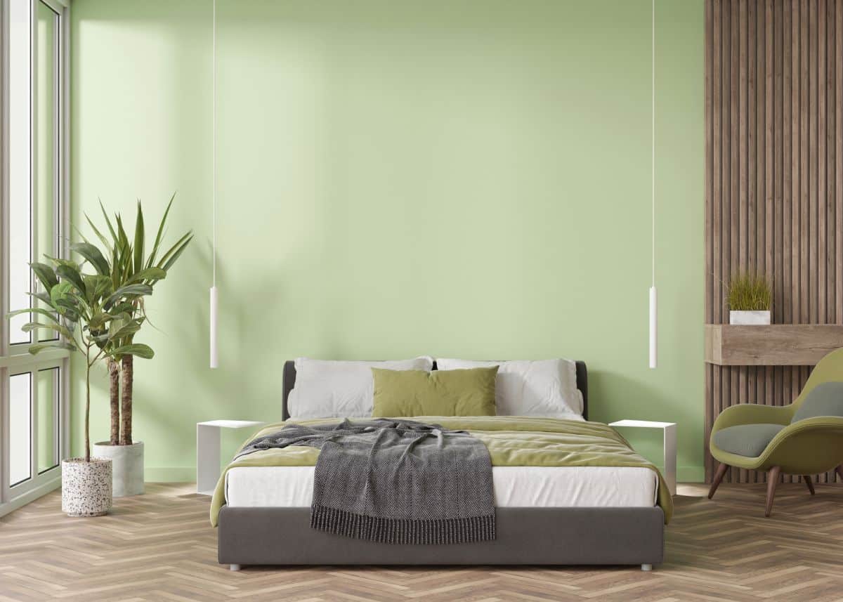 empty light green wall in modern bedroom, with minimalist pendant lights hanging from ceiling on either side of the bed