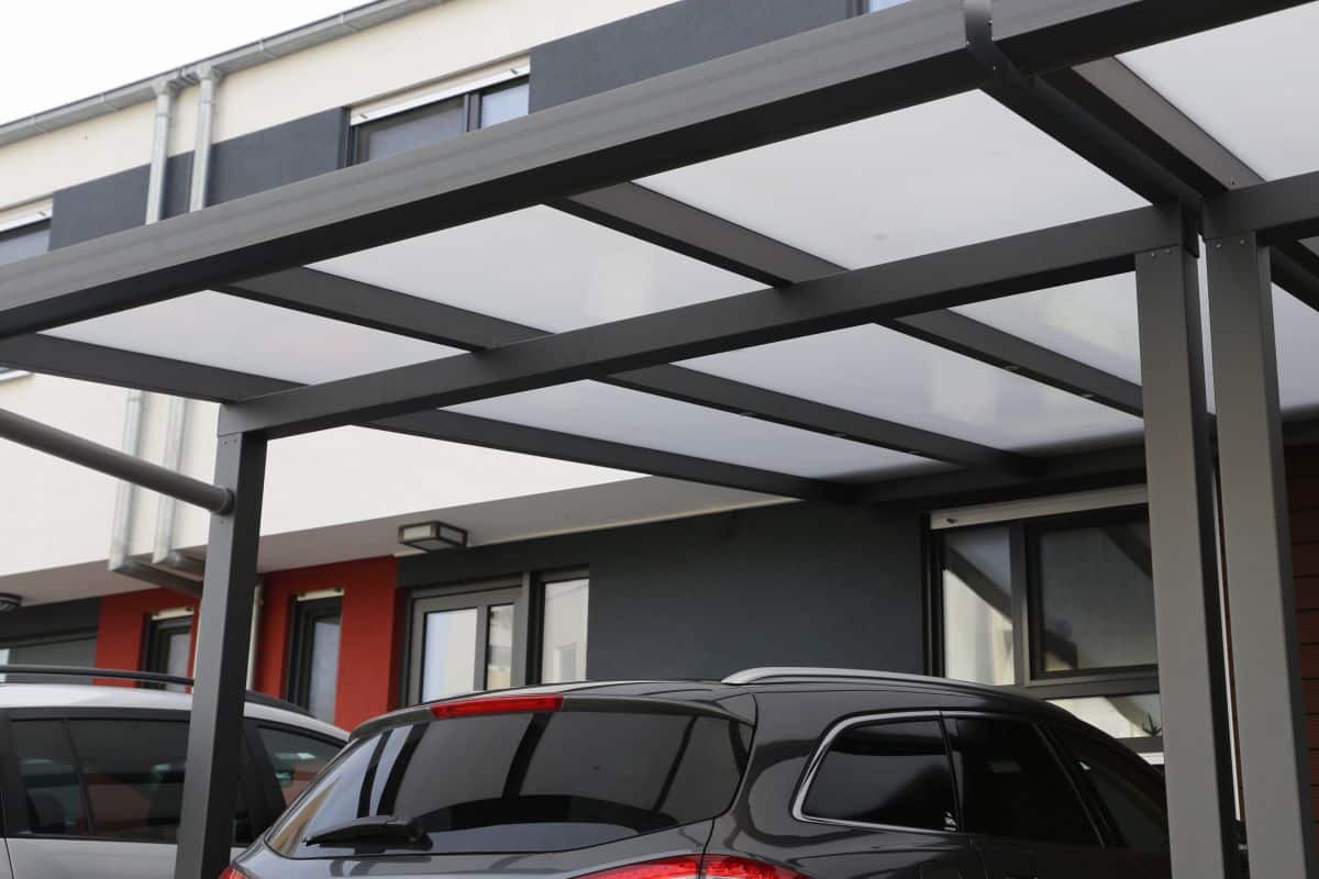 black car parked in a modern carport with steel black posts in residential home