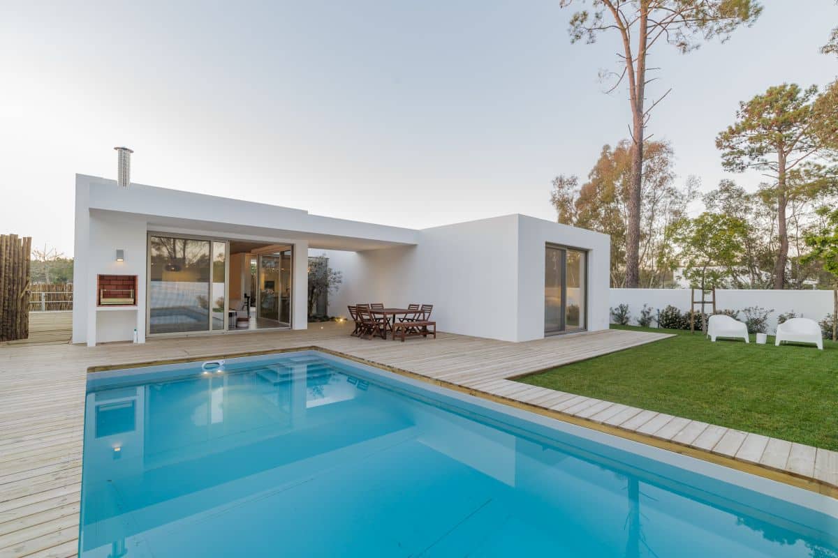 Modern pool house with garden and wooden deck. Outdoor dining area