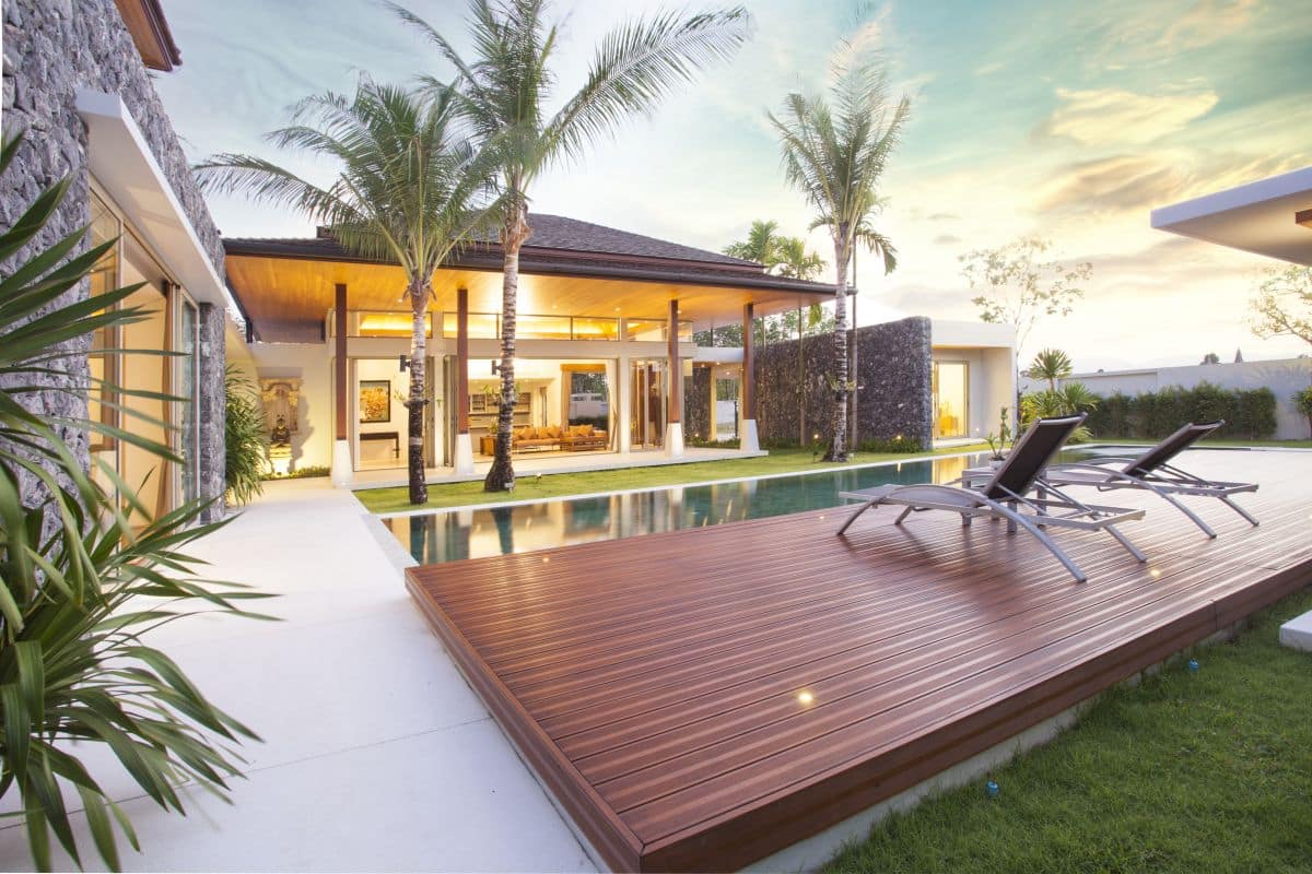 Spacious modern luxury pool villa. Featuring wooden decking, sun beds, swimming pool, and garden