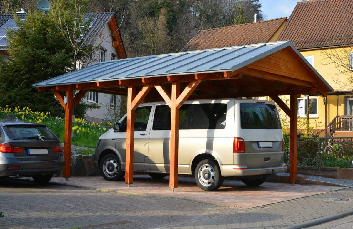 wooden carport with standing seam metal roof in front of a house 