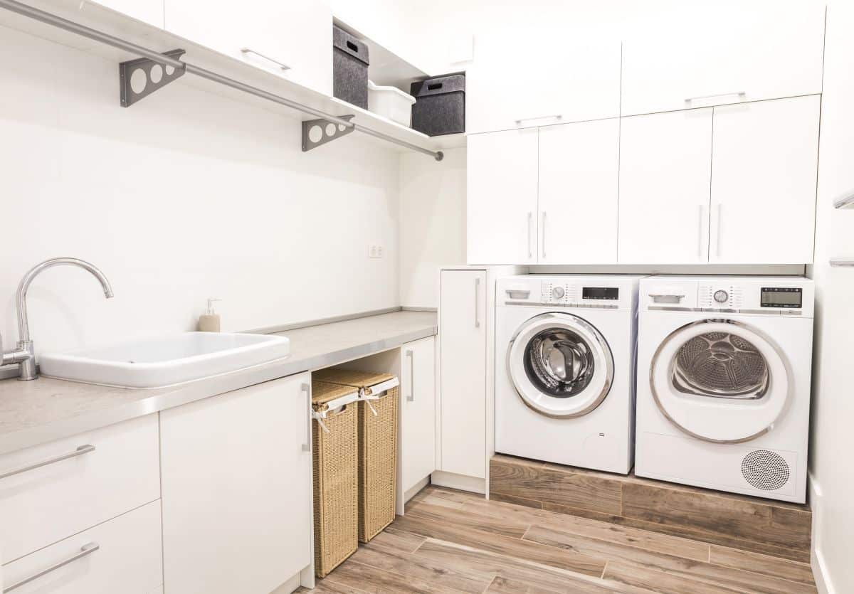 Modern laundry room with wall-mounted shelves and floor cabinets