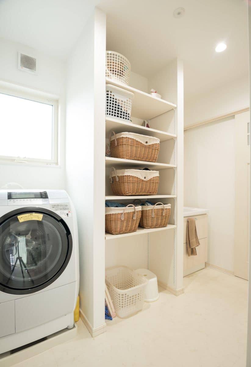 Open shelving with woven baskets and plastic baskets in laundry room