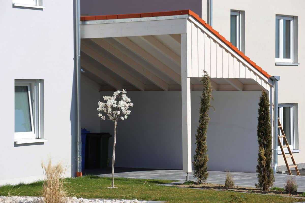 carport with slanted roof on the side of a house