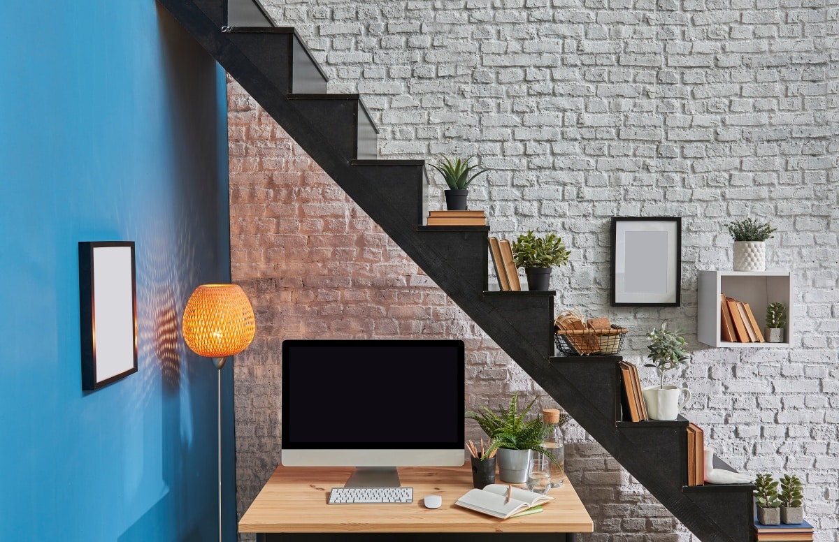 wooden desk and desktop under black stair,