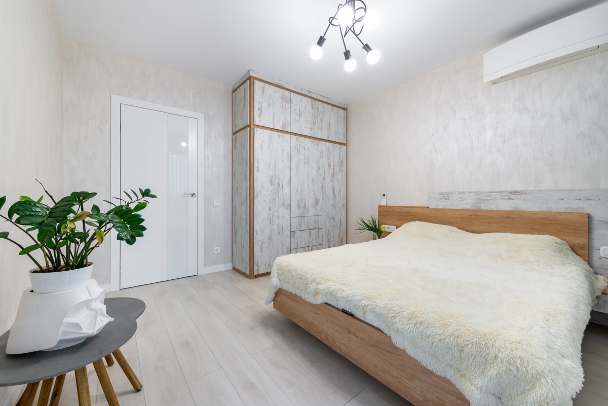 Interior of bedroom with fuzzy bedding and quirky modern lighting