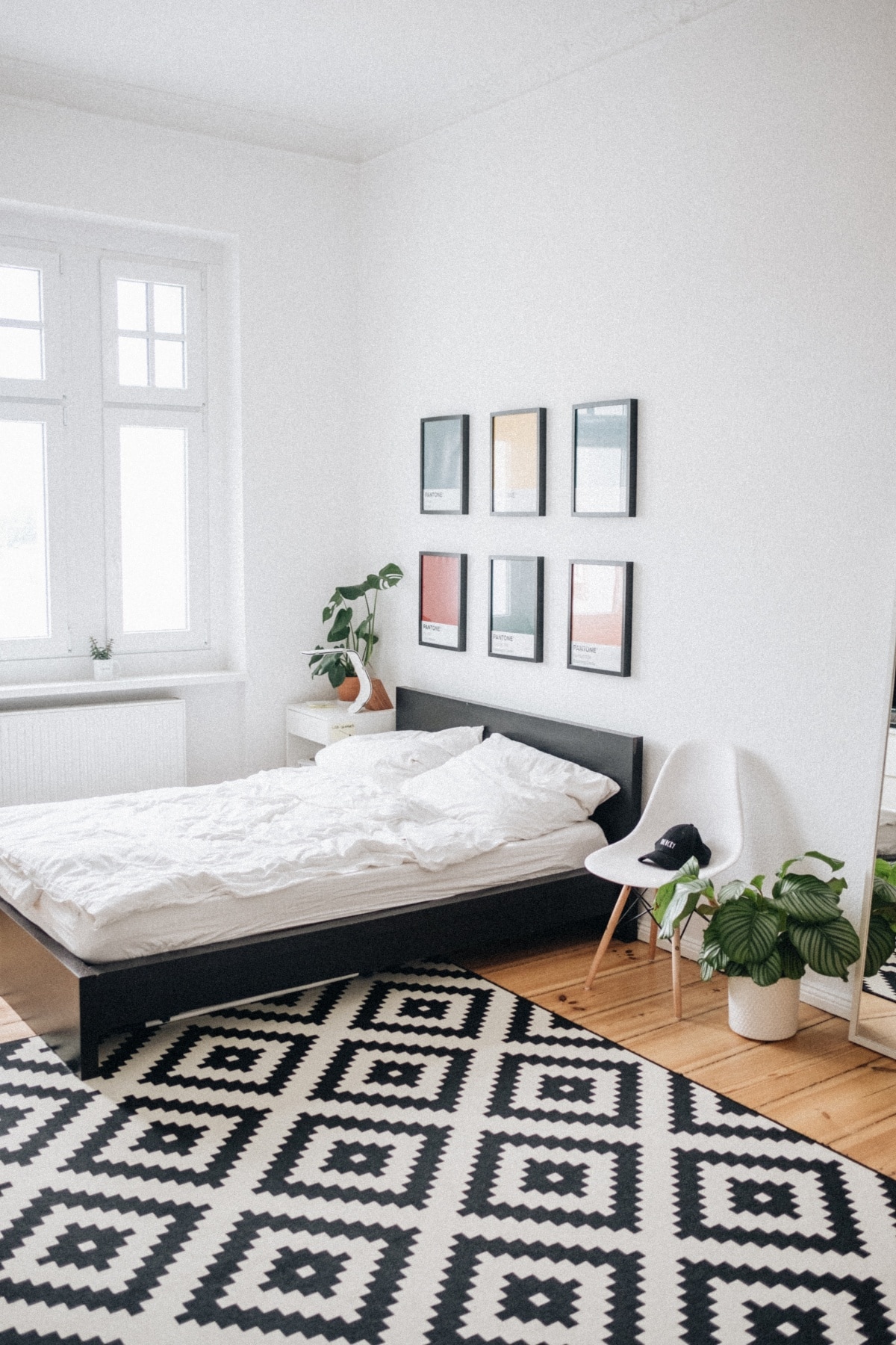 White bedroom with wood floor and patterned rug