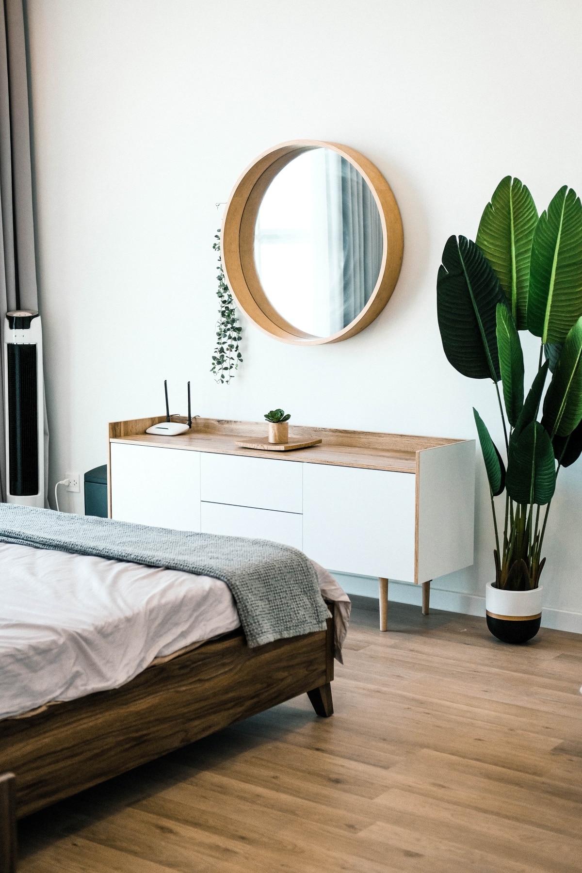 Minimalist white bedroom with mirror and plants