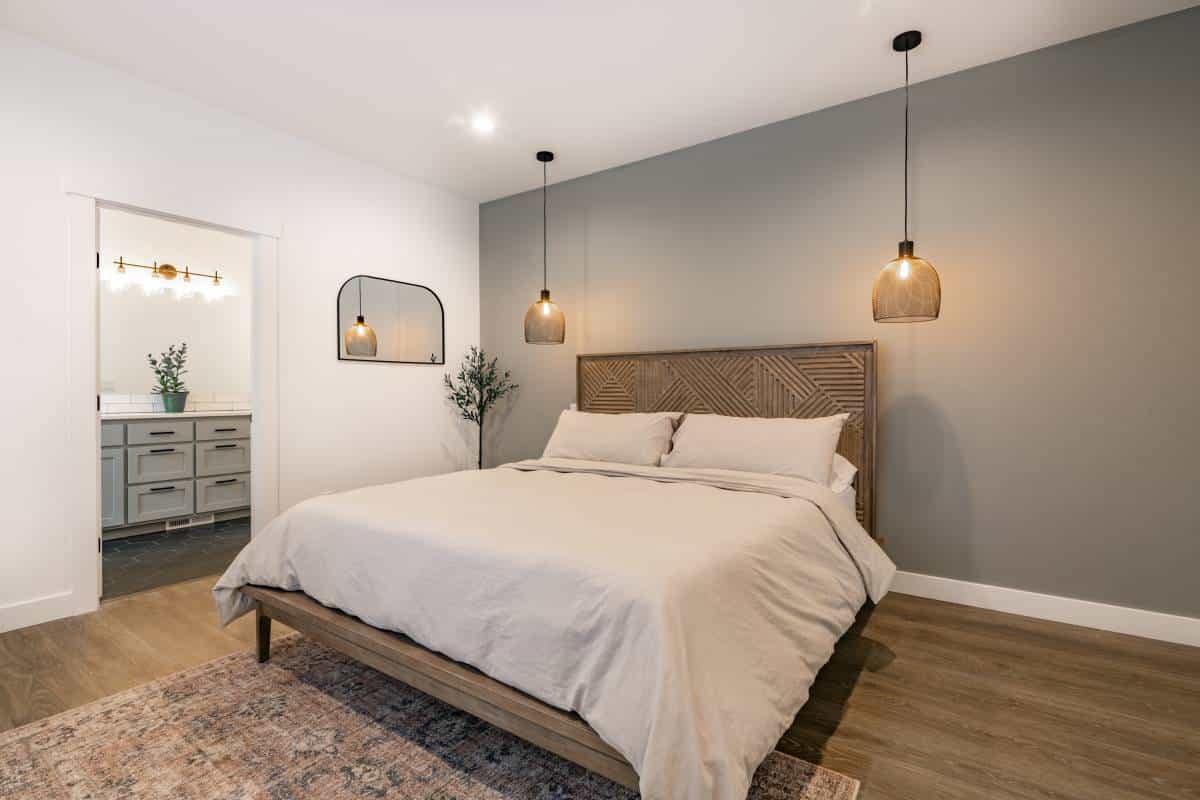 modern farmhouse style bedroom with white walls, deep yellow simple decor, made bed and basket light fixtures