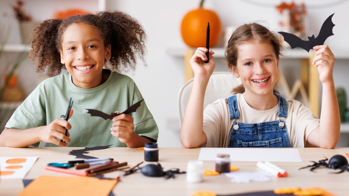 Two girls making DIY halloween decorations.