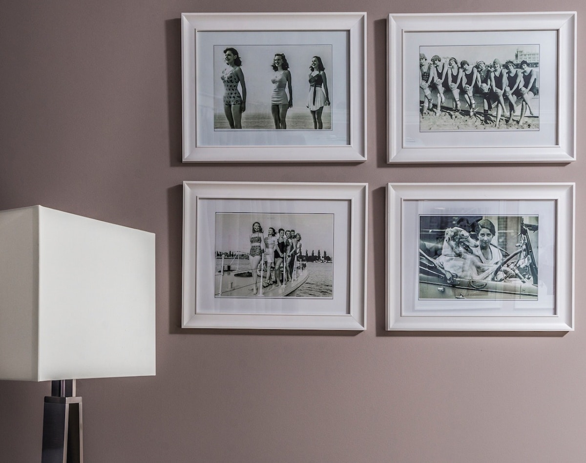 Four black and white photos in matching cream frames hung on a wall