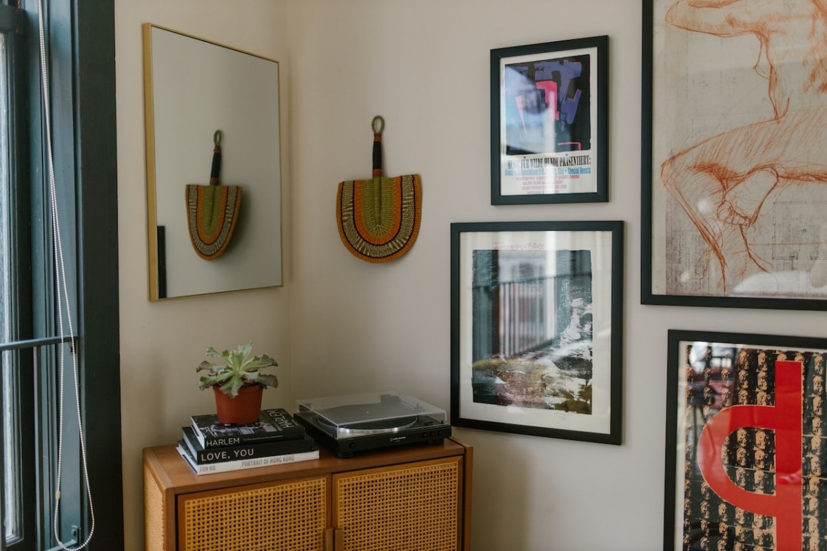 corner in a home with a console table and a mirror, wall decorations, and framed illustrations on the wall