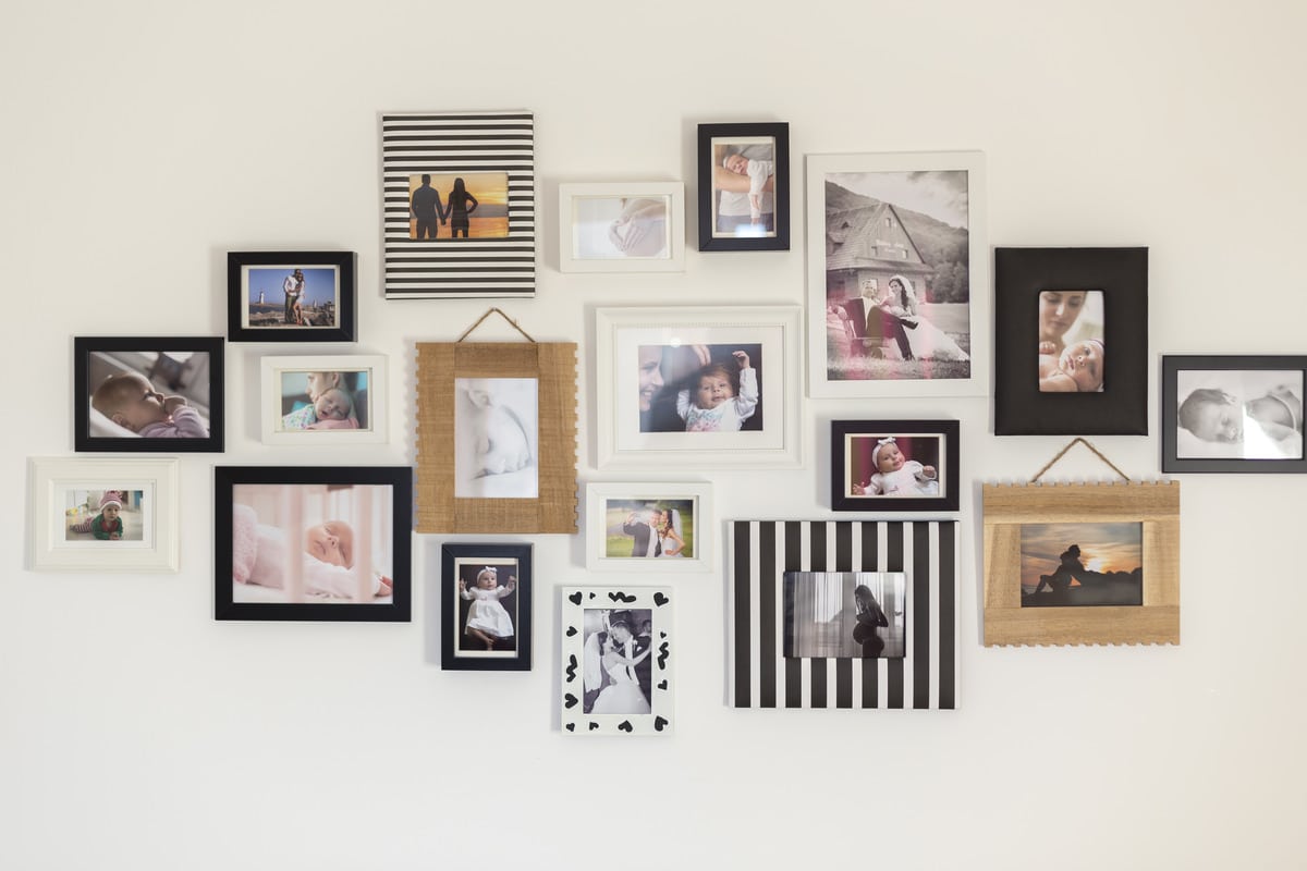 white wall with photos of a family in various photo frames