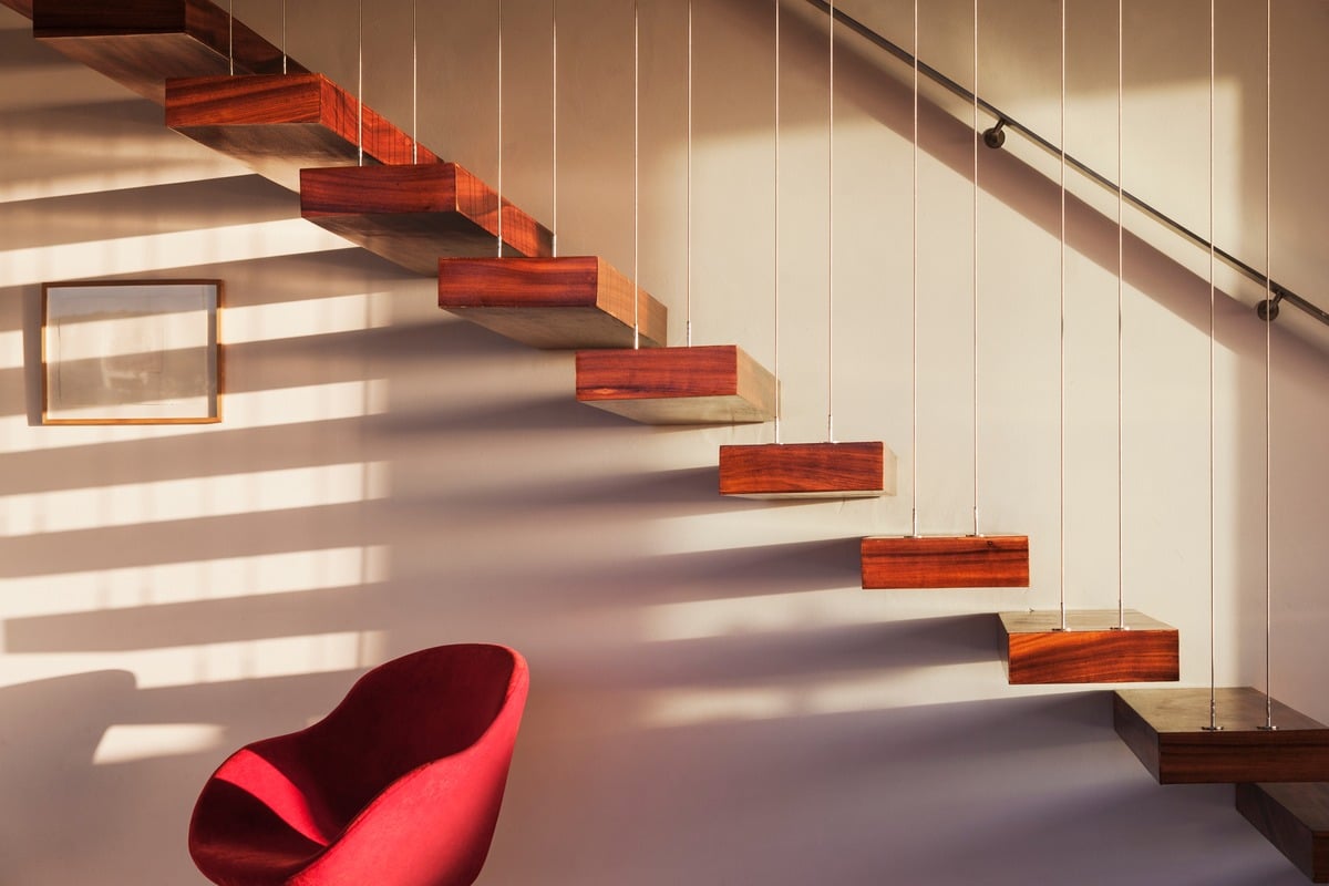 Floating staircase supported by thin metal railings in modern house